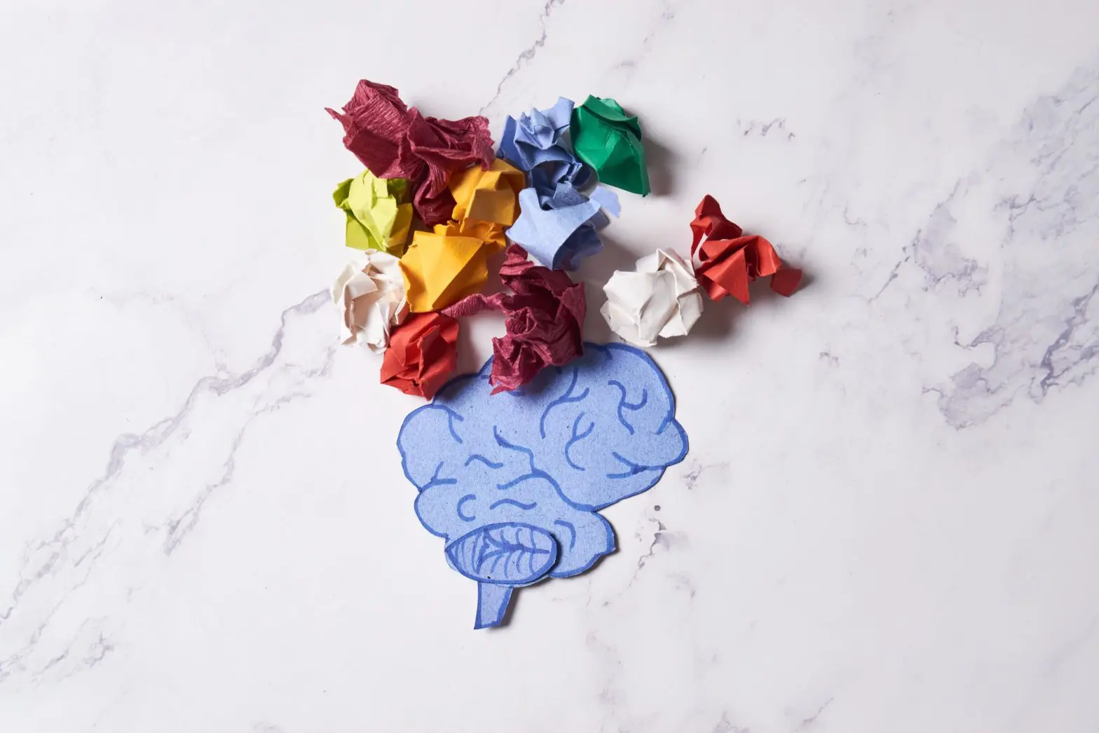 a paper cut out of a brain with many colored paper balls