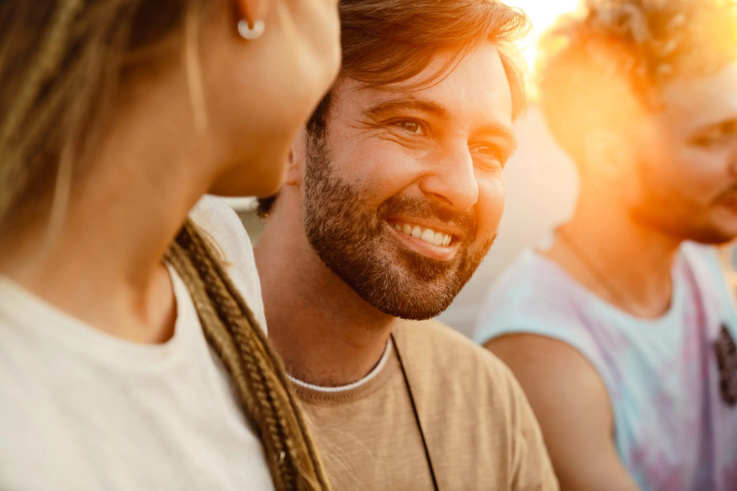 a man smiling with a woman in the background