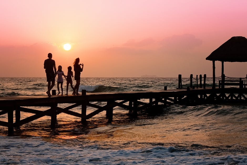 a family on a pier at sunset, knowing there are answers on how to help a loved one with addiction