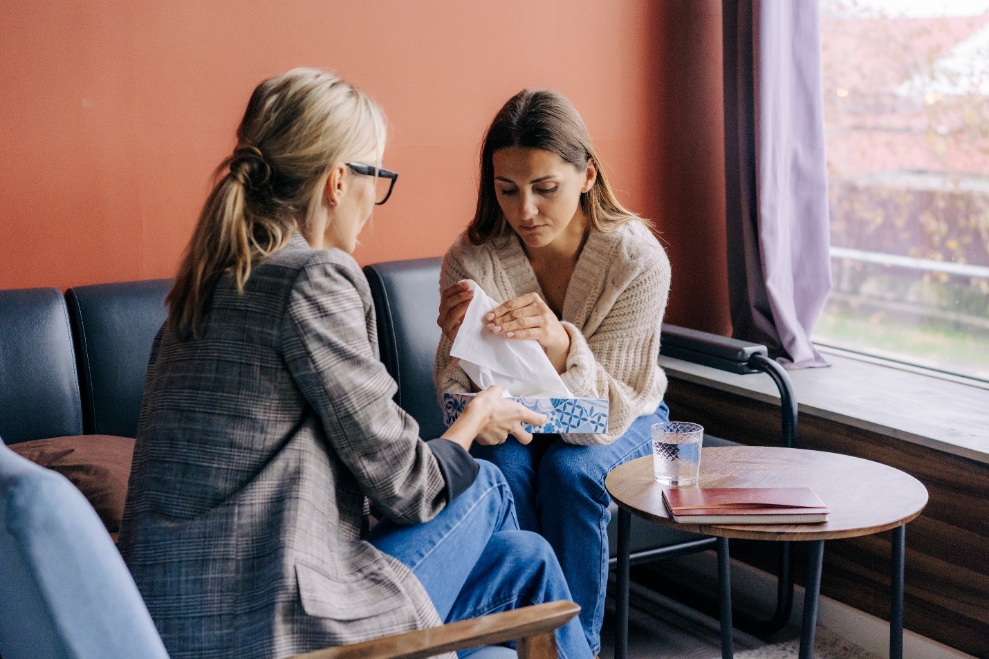 A young woman meeting with a therapist to address trauma and addiction