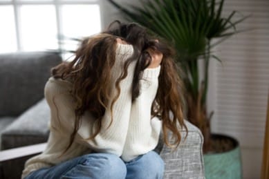 A woman with her head buried in her arms as she learns about the alarming statistics about addiction