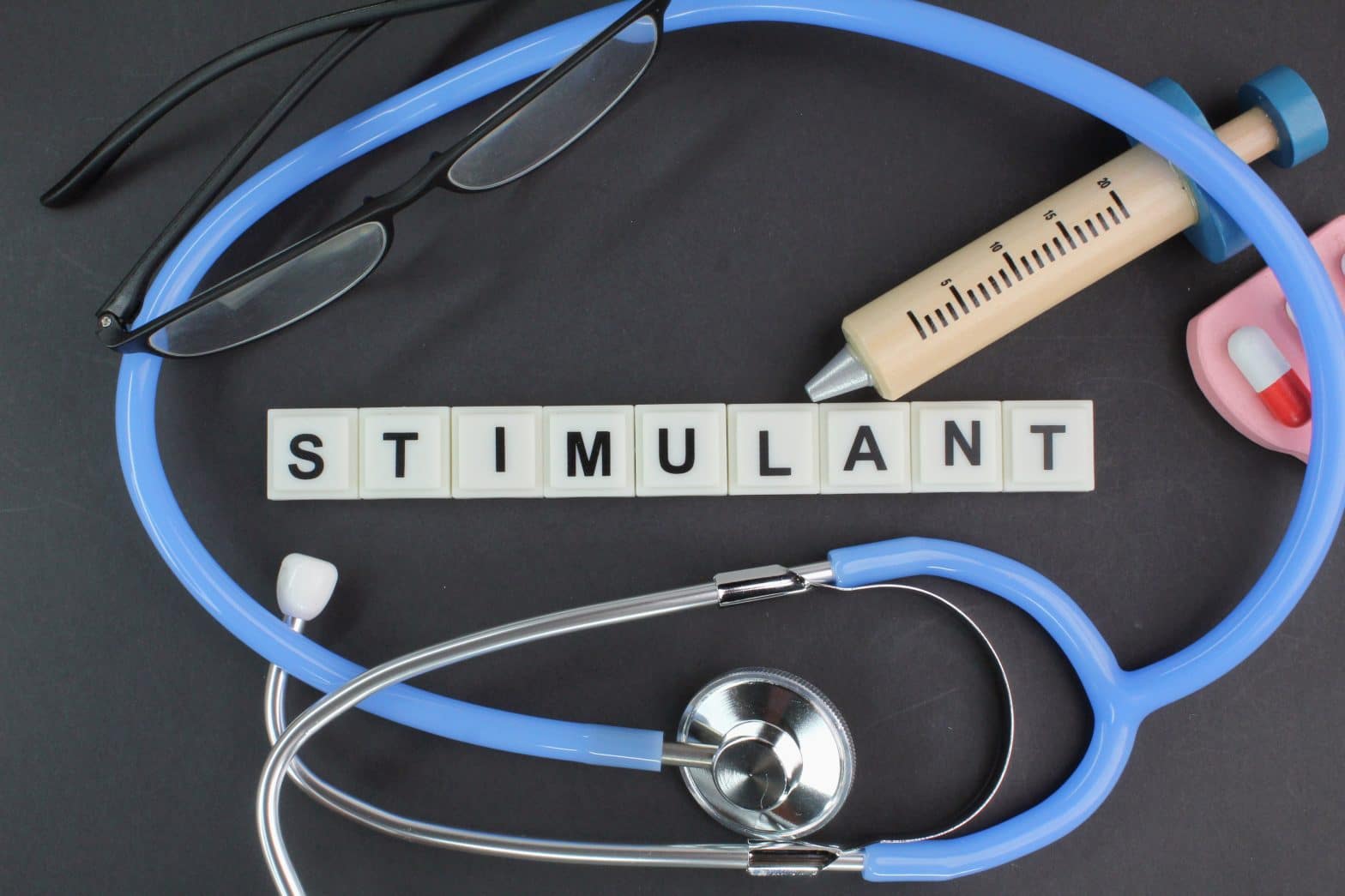 a stethoscope and a pen on a black surface