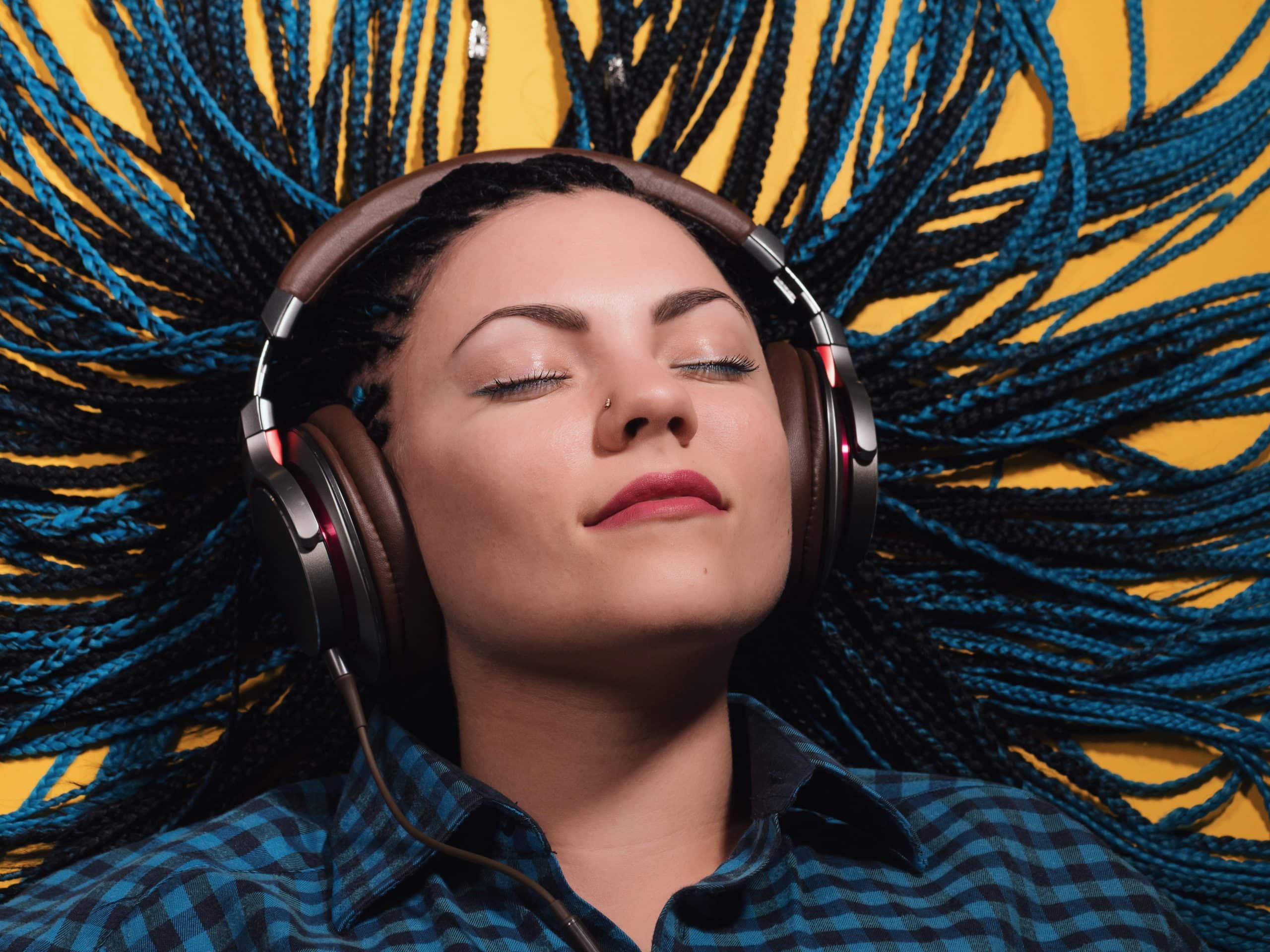 a woman lying down with headphones on her head