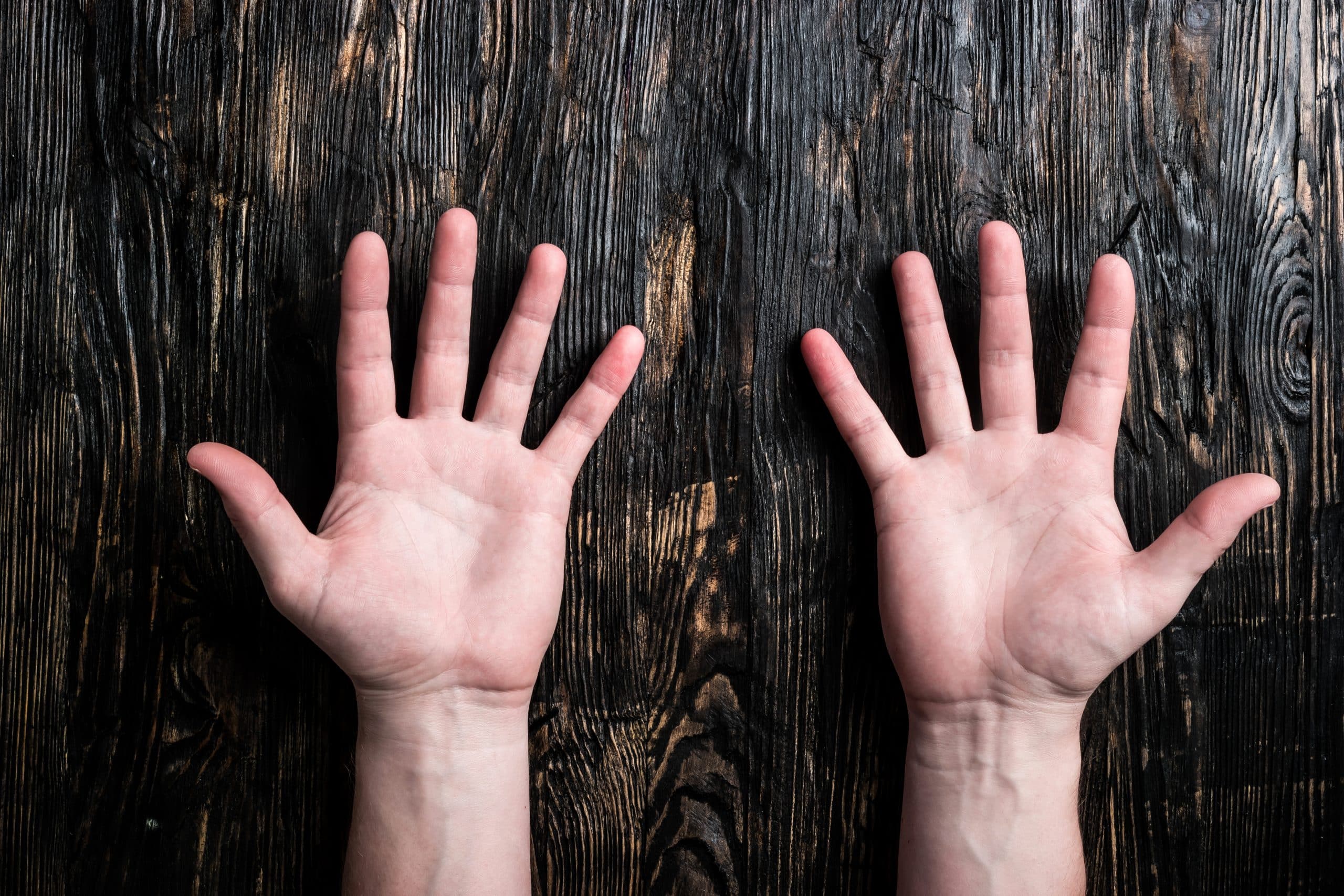 a pair of hands on a wooden surface