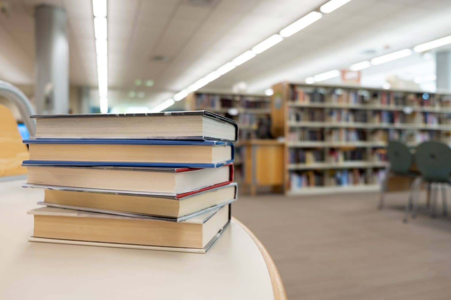 a stack of books on a table in a library