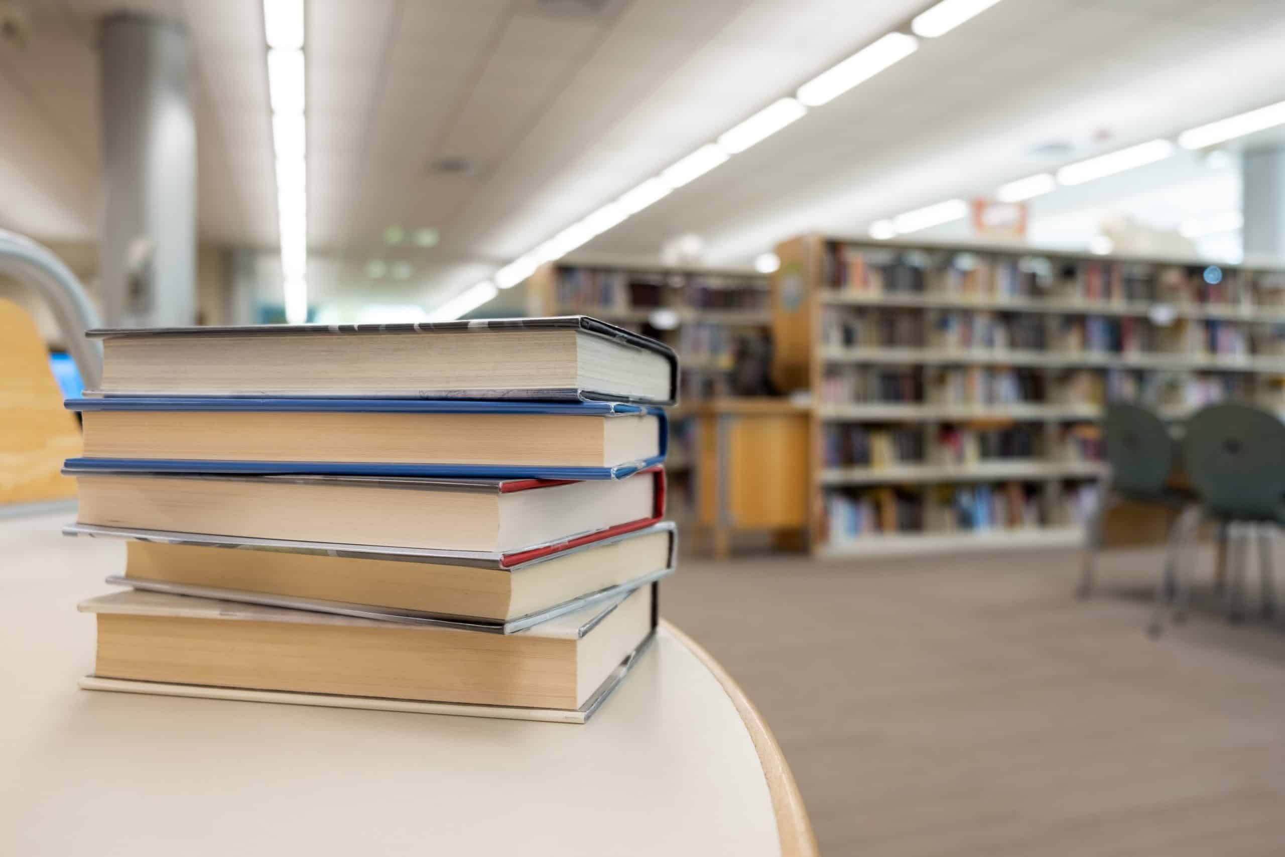 a stack of books on a table in a library