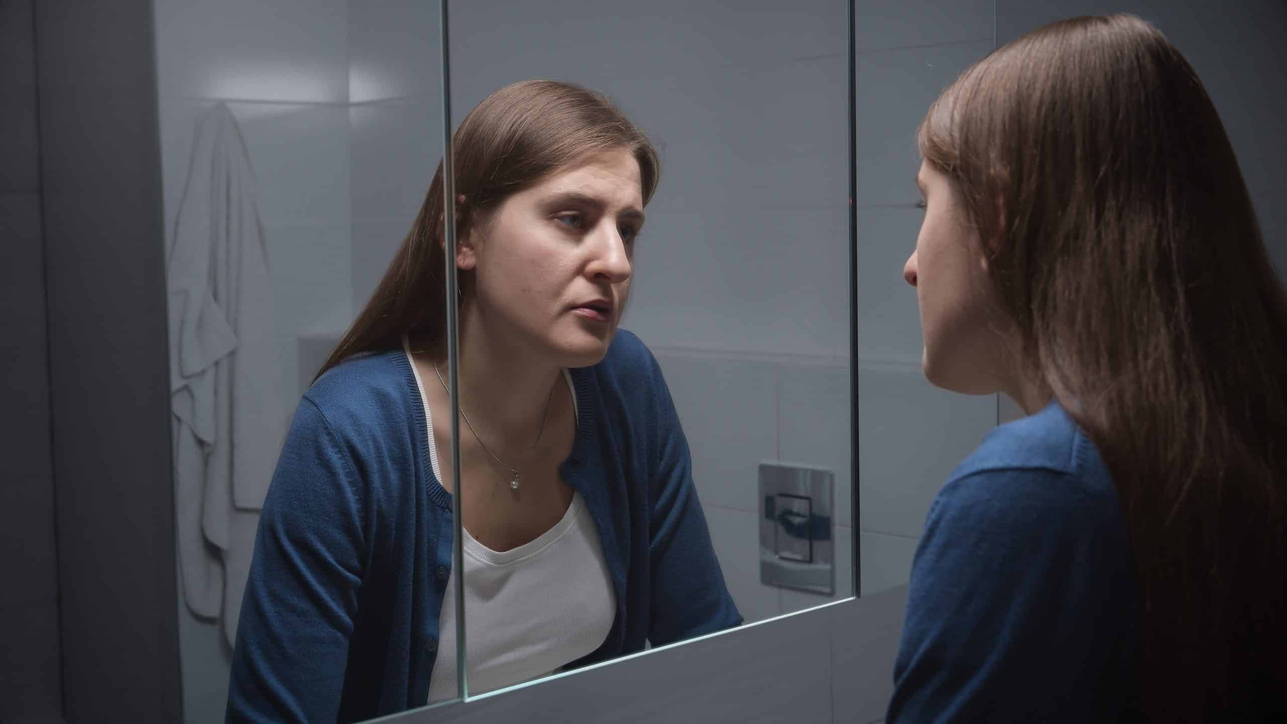 a woman looking at herself in a mirror
