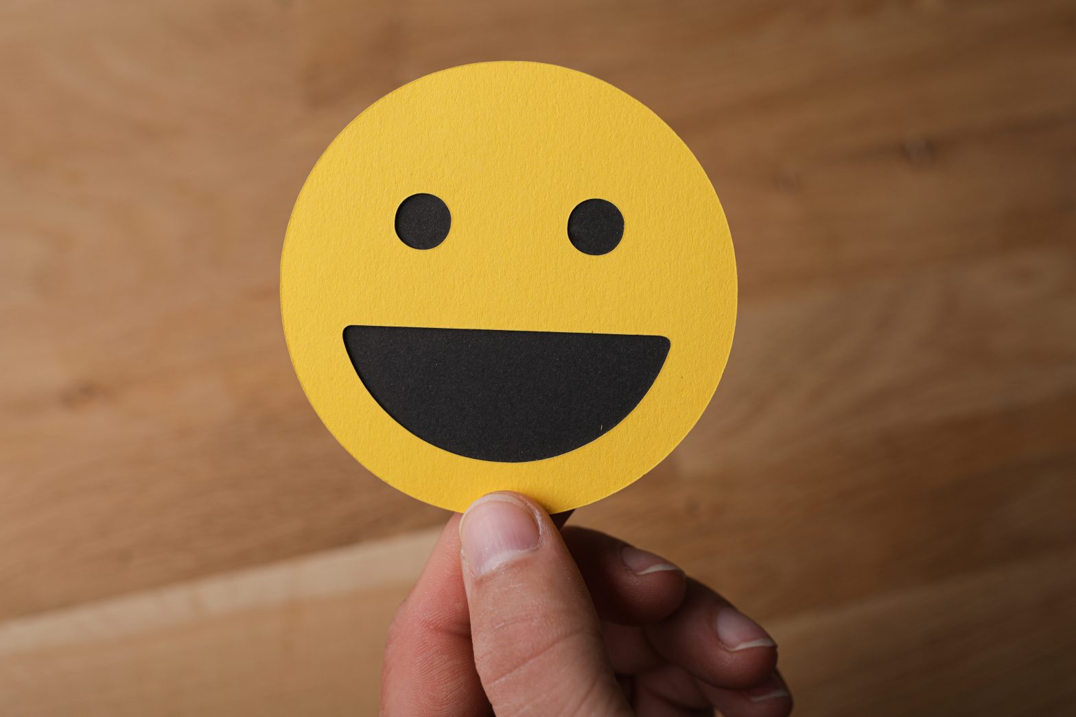 a hand holding a yellow emoji