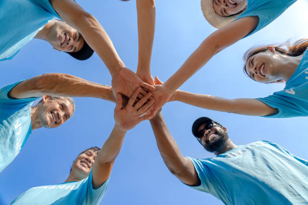 a group of people putting their hands together