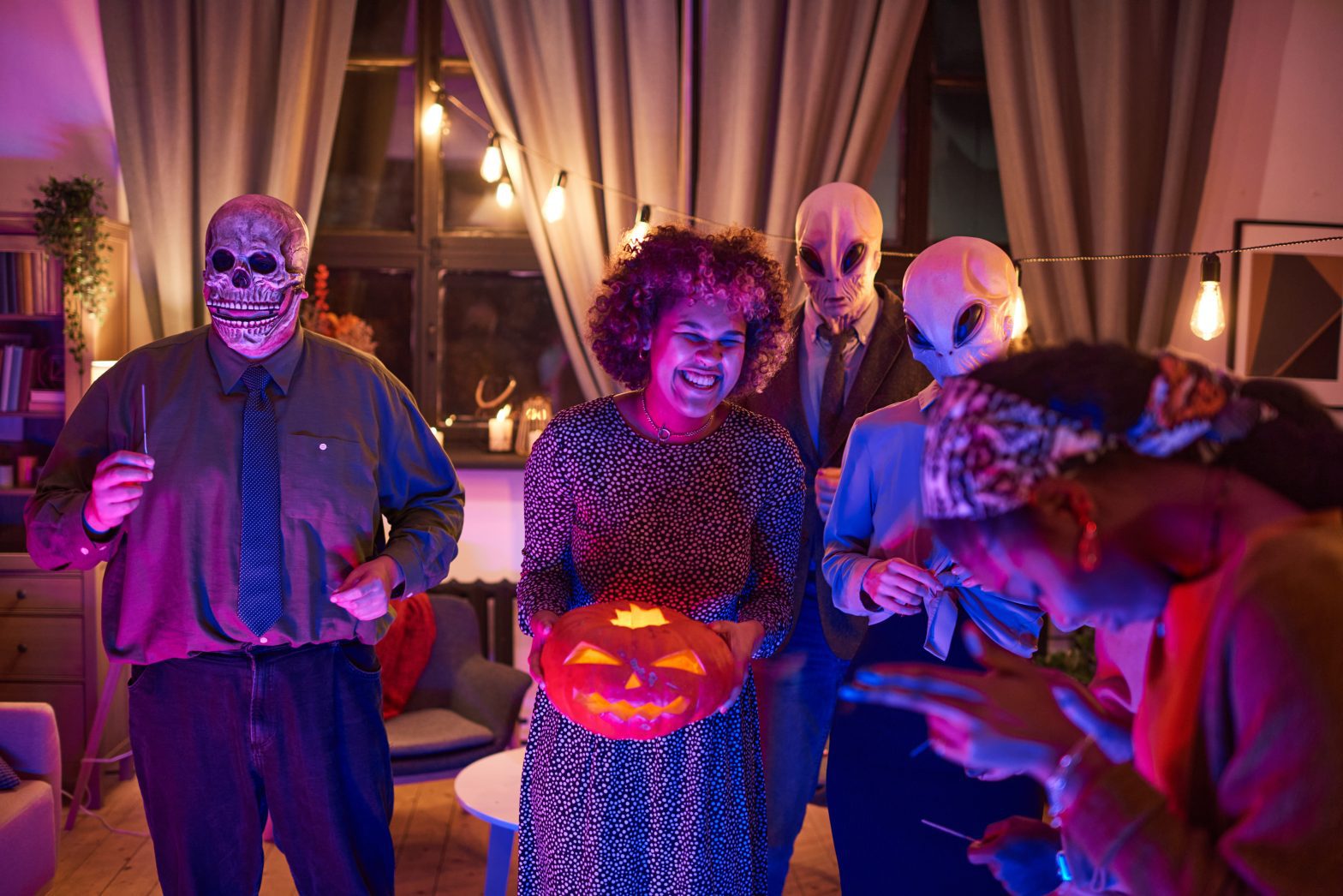 a woman holding a pumpkin in front of people in clothing
