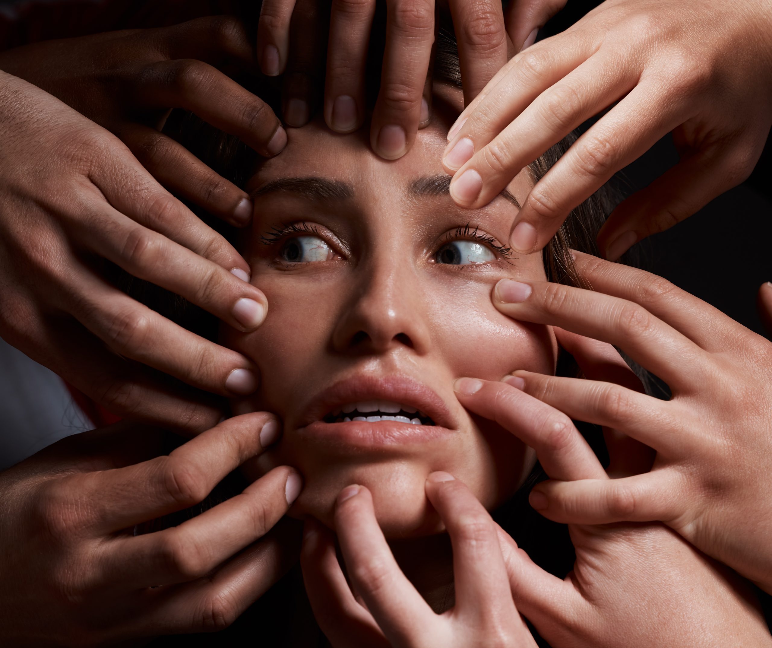 a group of hands around a woman's face