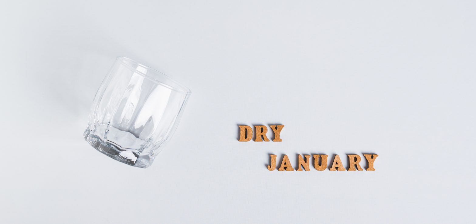 empty glass on grey background with the words "dry january" to highlight dry january activities