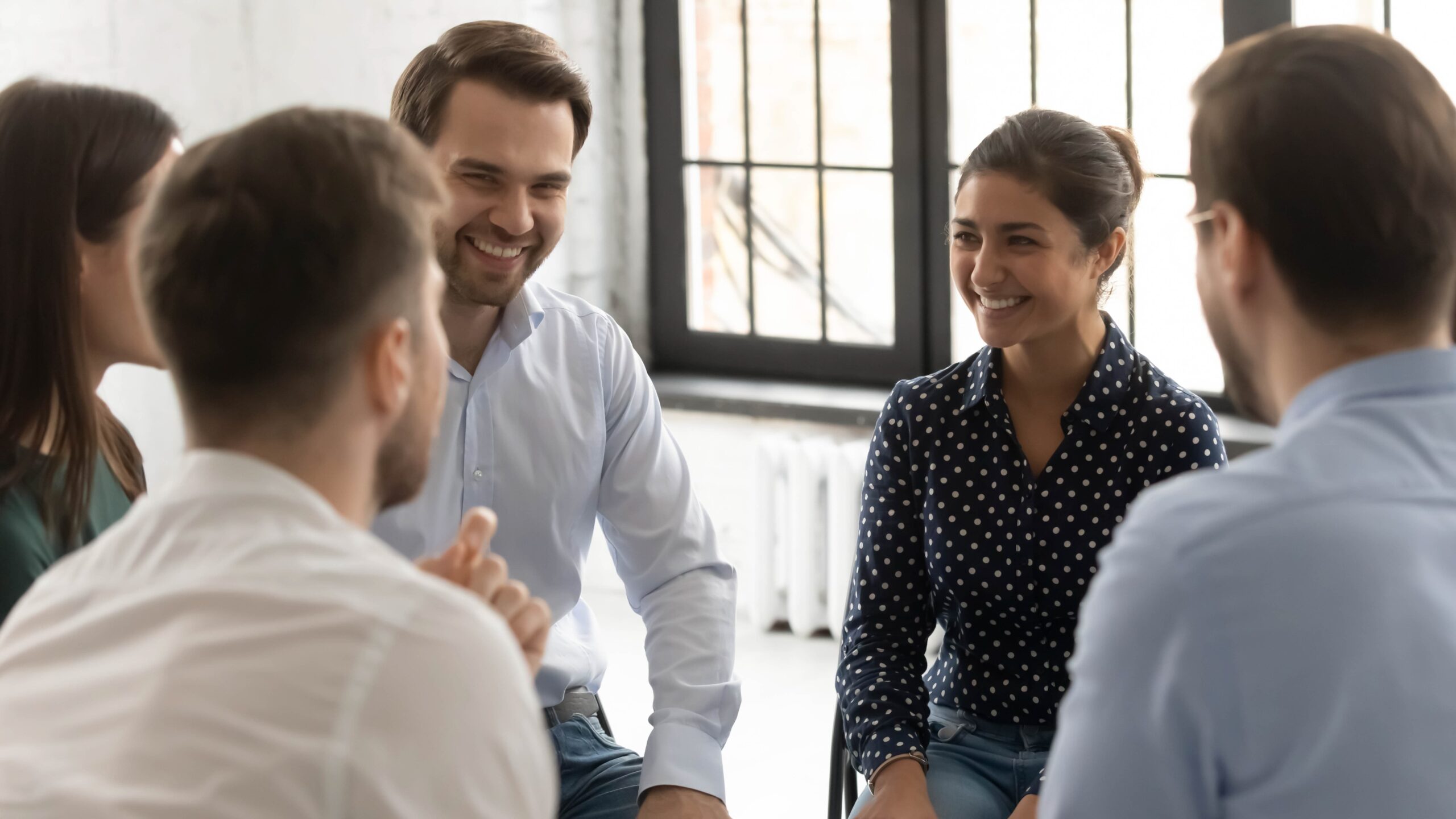 Group therapy session with people smiling and engaging in discussion scaled Why Step 5 Is a Turning Point in the 12-Step Program