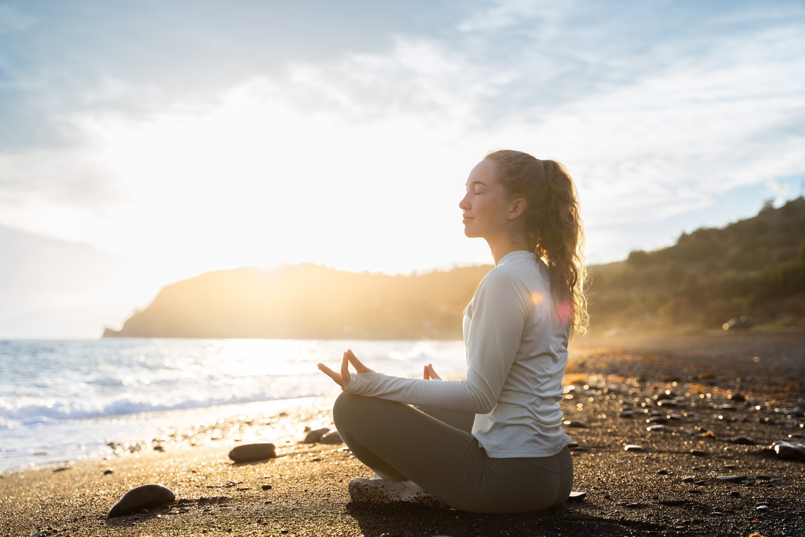 Individual meditating peacefully at sunrise, reflecting on thoughts during recovery