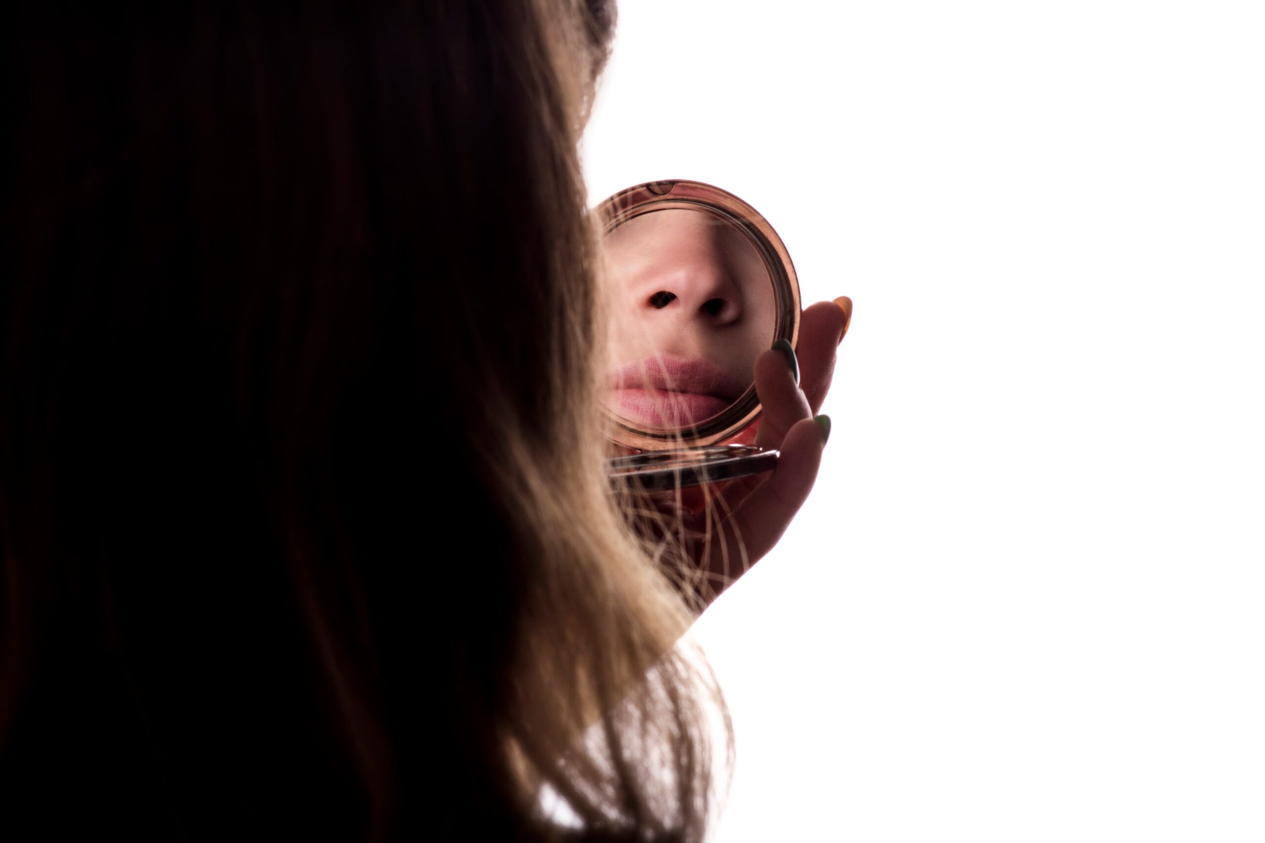 A person looking into a mirror reflecting a clear, healthy version of themselves, representing finding identity beyond addiction.