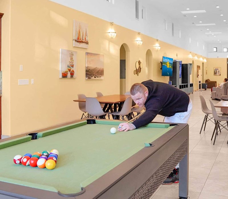 2 a man playing pool in a room