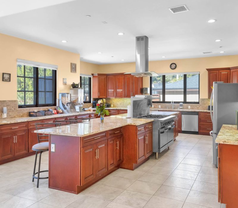 a large kitchen with a large island and stainless steel appliances