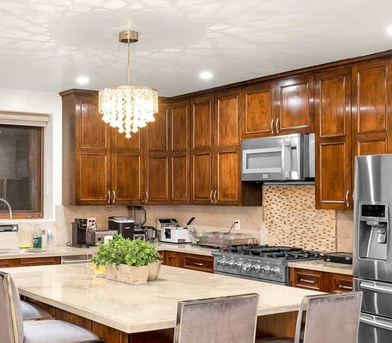 a kitchen with a large island and a chandelier