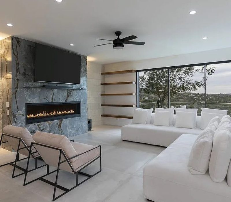 a living room with a fireplace and white couches