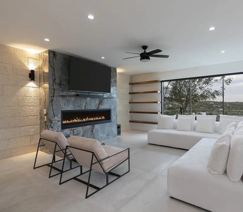 a living room with a fireplace and white couches