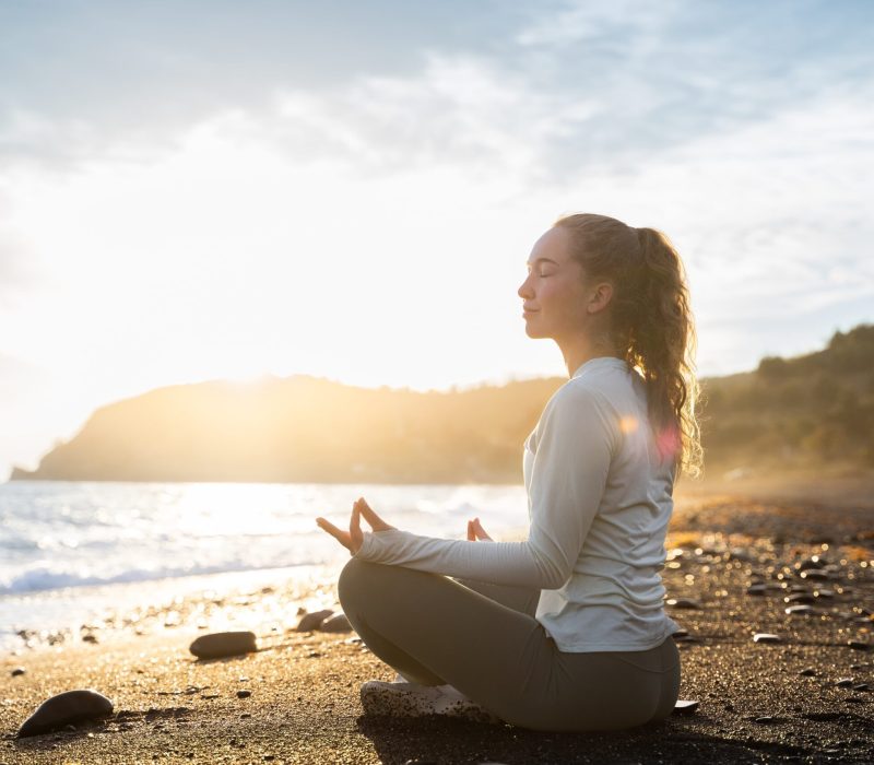 Individual meditating peacefully at sunrise, reflecting on thoughts during recovery